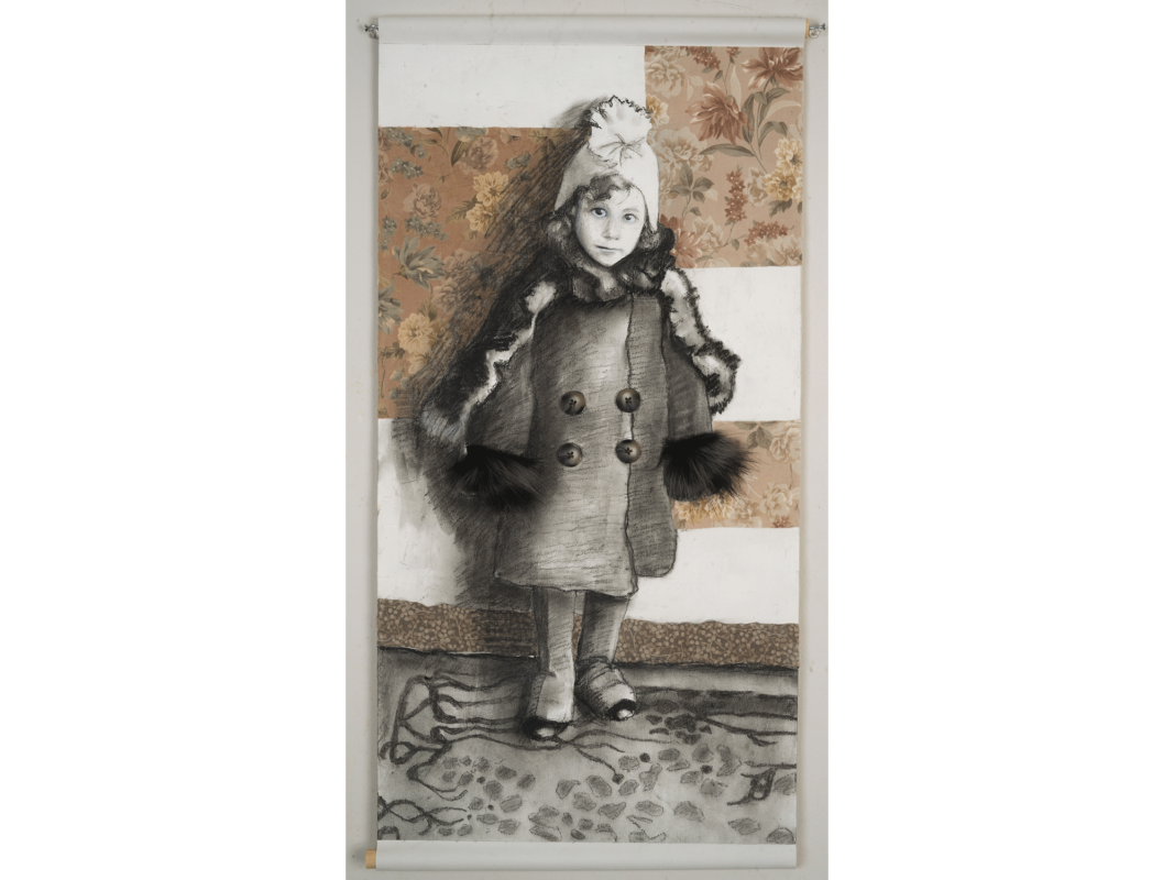 The artwork titled "Lucky Girl" was created in 2018 by Deborah Addison Coburn. The image is a charcoal drawing of a small Polish girl wearing a a white hat, a fur shawl, and a large pea coat trimmed with fur. The girl stares directly at the viewer. The drawing of the young girl is set against a backdrop that alternates between white blank spaces and squares of faded floral wallpaper. The artwork is a charcoal drawing on paper mounted on canvas with fabric and buttons, 14 inches by 26 inches.